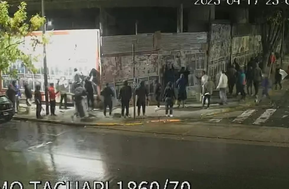 El grupo de personas, pegando los afiches que escrachaban a Clarín.