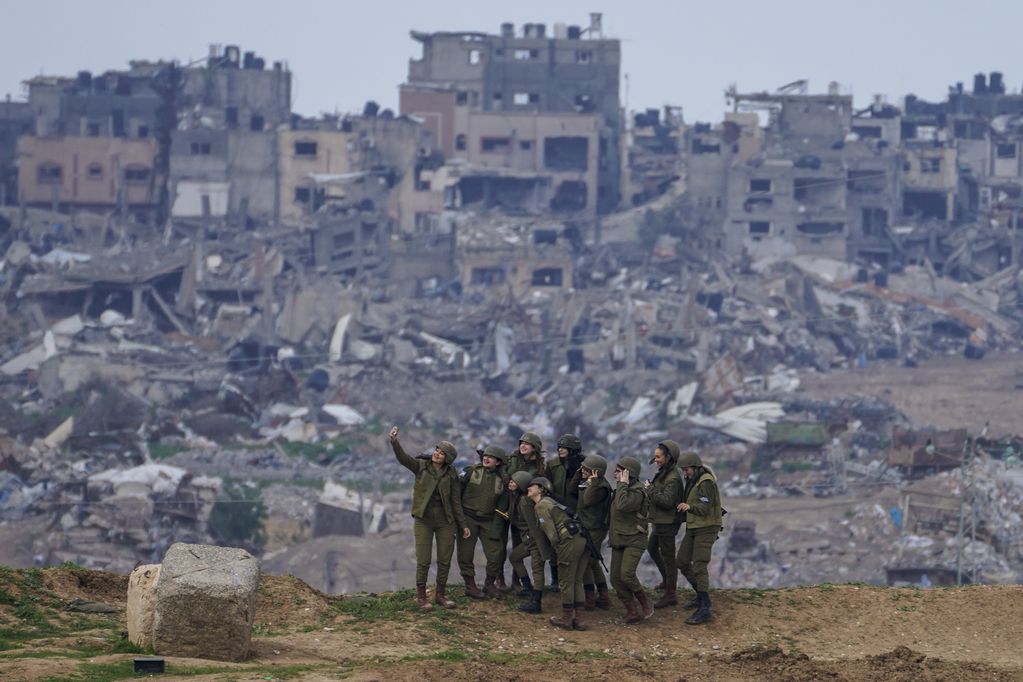 Mujeres soldado israelíes posan para una fotografía en la frontera con la Franja de Gaza, en el sur de Israel, el lunes 19 de febrero de 2024.