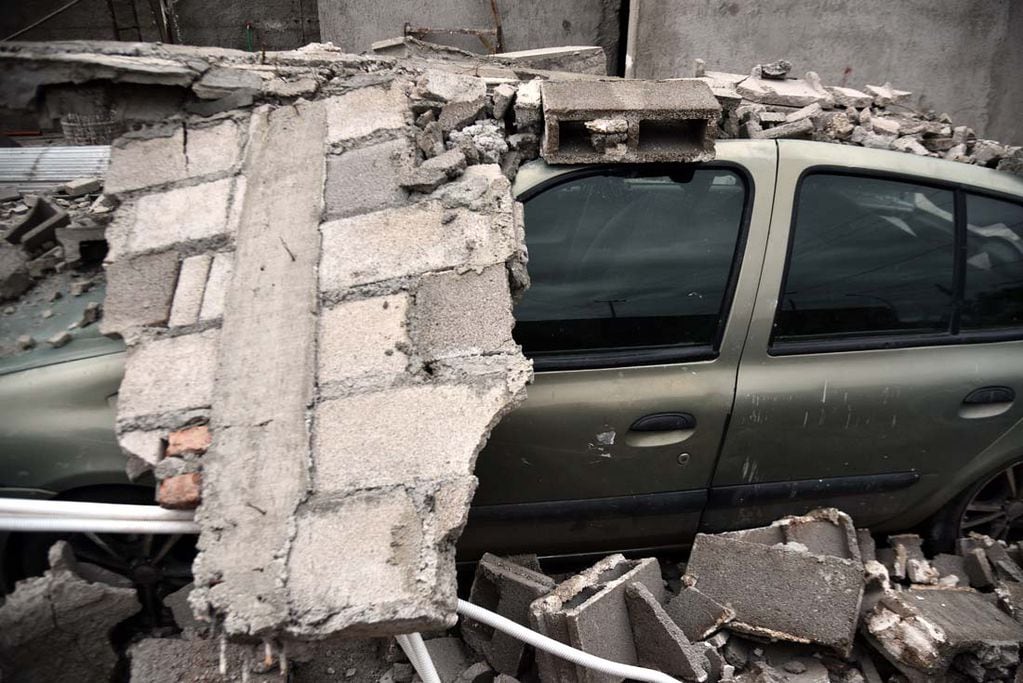 Cuatro autos aplastados al derrumbarse una pared por el fuerte viento en barrio Carcano de la ciudad de Córdoba. El propietario contó que se escuchó una explosión fuerte cuando todo se vino abajo. (Pedro Castillo/ La Voz)