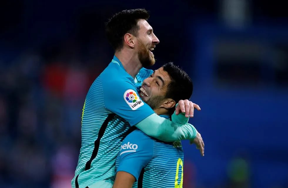 Barcelona's Lionel Messi, top, celebrates with teammate Luis Suarez after scoring their side's second goal against Atletico Madrid during a Spanish Copa del Rey semifinal first leg soccer match between Atletico Madrid and Barcelona at the Vicente Calderon