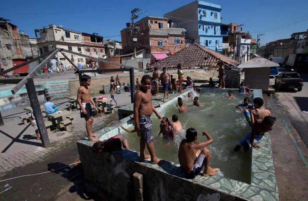 In this Aug. 13, 2015 photo, children play in a pool that has no system to replace the water in Rio de Janeiro, Brazil. Brazil is the worldu2019s seventh-largest economy, but ranked 84th for access to water and sanitation in last yearu2019s Yale Environmental Per