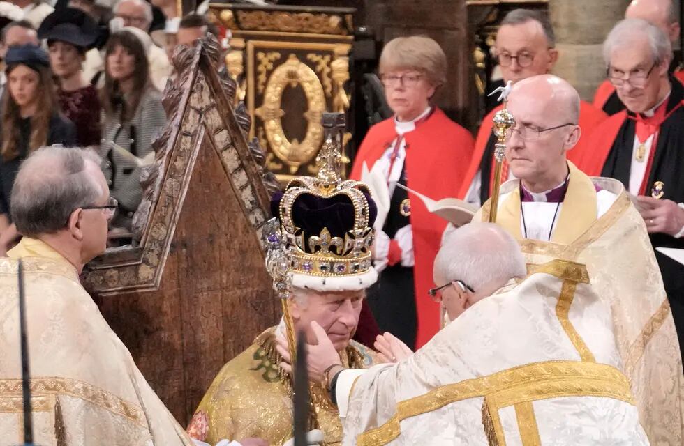 El rey Carlos III sentado mientras es coronado con la corona de San Eduardo por el arzobispo de Canterbury, el reverendo Justin Welby, durante la ceremonia de coronación en la Abadía de Westminster en Londres, el sábado 6 de mayo de 2023. (Jonathan Brady/Pool Photo vía AP)