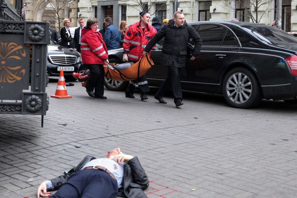 TOPSHOT - EDITORS NOTE: Graphic content / Medical workers carry the alleged gunman wounded after he shot dead former Russian MP Denis Voronenkov in central Kiev on March 23, 2017.

Ukrainian President blamed Russia for the murder of Voronenkov, who moved to Ukraine last year and was wanted by Russia for fraud, saying it was an "act of state terrorism."  / AFP PHOTO / Sergei SUPINSKY