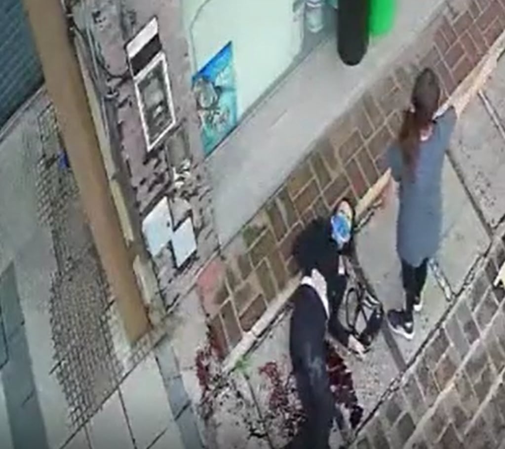 La víctima, ya sangrando, es asistida por vecinos para luego ser trasladada al hospital. Captura de video.