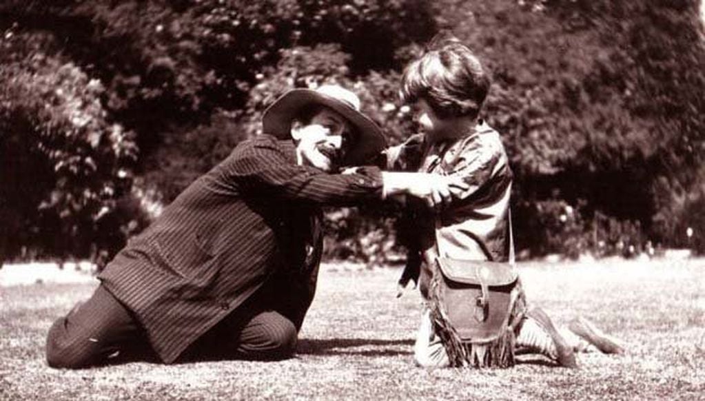 James M. Barrie jugando con uno de los niños de la familia. 