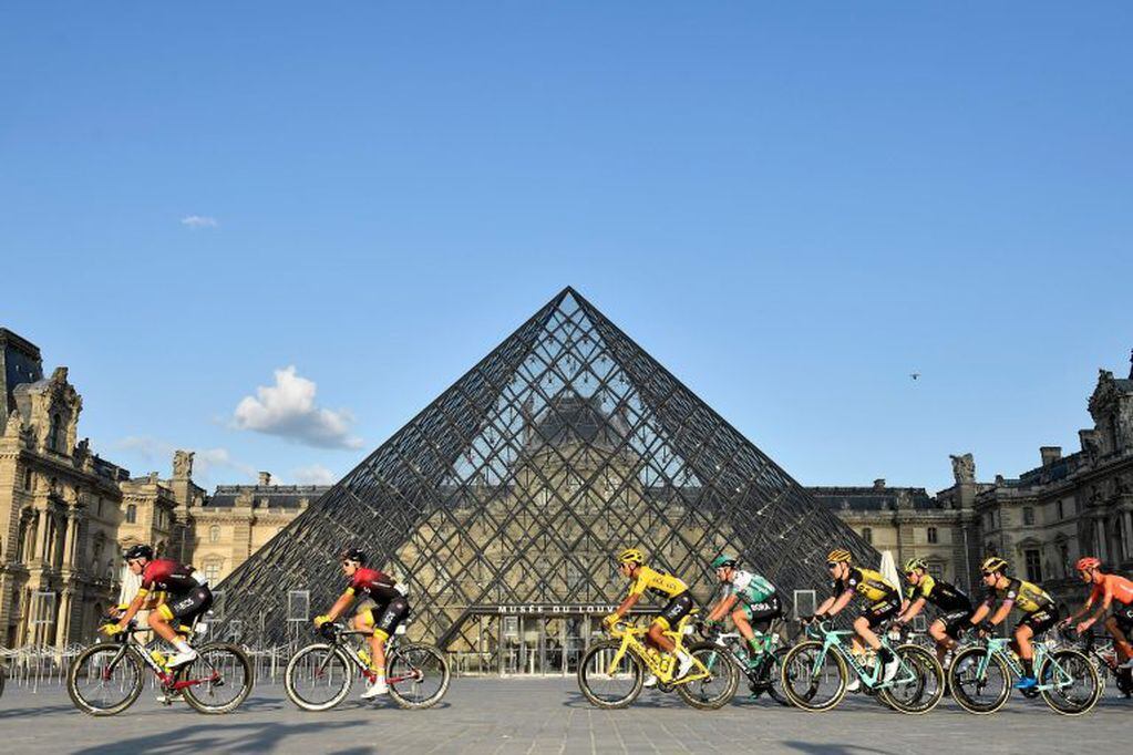 Los ciclistas pasan frente al Museo del Louvre. (Foto: Julien DE ROSA / POOL / AFP)