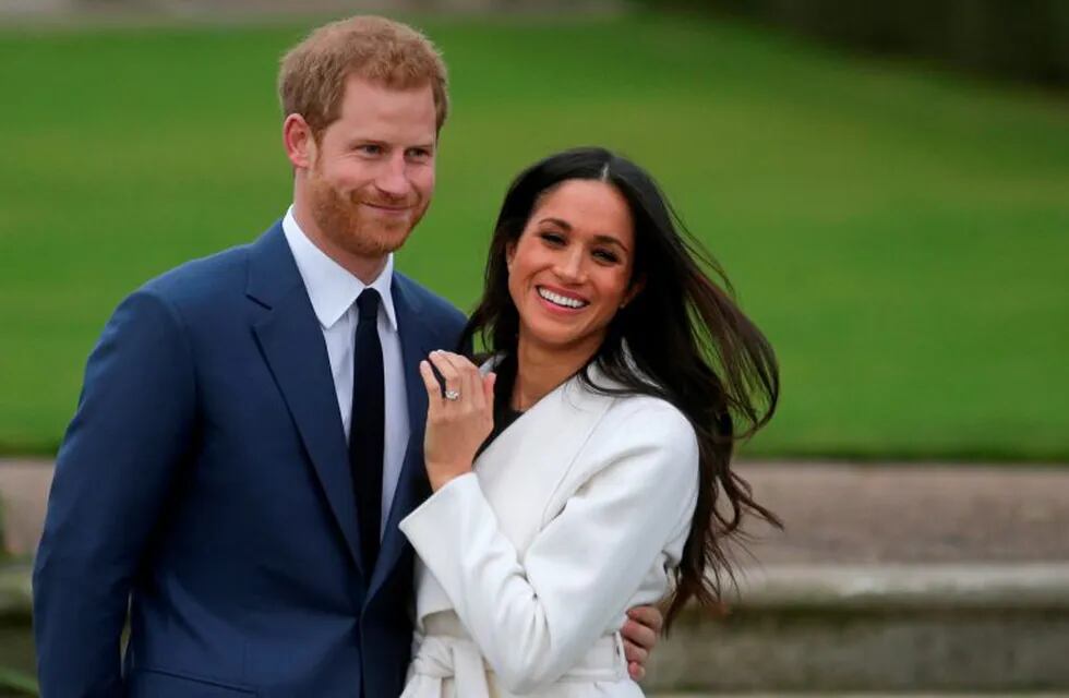 (FILES) In this file photo taken on on November 27, 2017, Britain's Prince Harry stands with his fiancee US actress Meghan Markle as she shows off her engagement ring whilst they pose for a photograph in the Sunken Garden at Kensington Palace in west London, following the announcement of their engagement. - Britain's Prince Harry and his wife Meghan will give up their titles and stop receiving public funds following their decision to give up front-line royal duties, Buckingham Palace said on January 18, 2020. \
