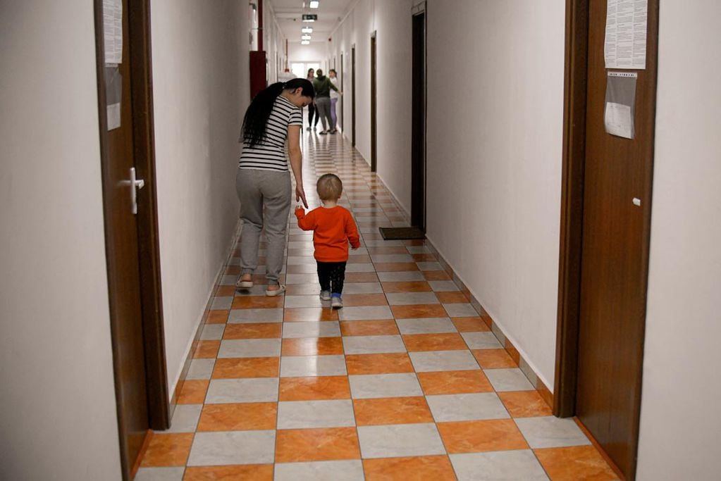Una mujer camina con un niño en el pasillo de un centro de refugiados en Bucarest, Rumania. 
