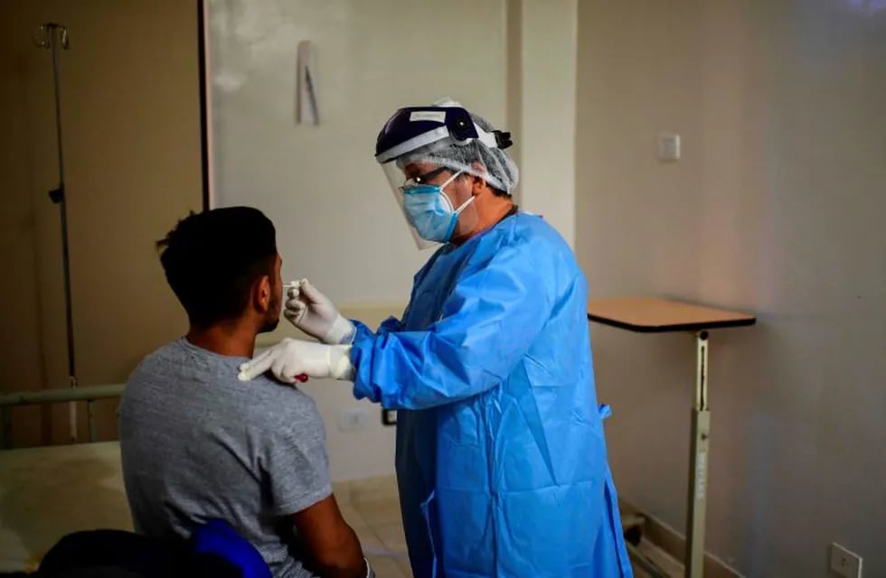 Doctor Ricardo Carrera (R) takes a swab sample from a man to be tested for COVID-19 at the Doctor Alberto Antranik Eurnekian Public Hospital in Ezeiza, in the outskirts of Buenos Aires on July 1, 2020. (Photo by RONALDO SCHEMIDT / AFP)  CASOS DEL DIA CORONAVIRUS  PACIENTE CON COVID - 19  ARGENTINA   CASOS DEL DIA CORONAVIRUS  PACIENTE CON COVID - 19  ARGENTINA    INFECTADO INFECTADA INFECTADOS  HISOPADO