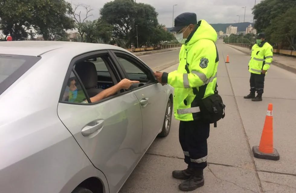 Efectivos policiales realizan controles vehiculares en calles y puentes de Jujuy, solicitando los permisos de circulación.