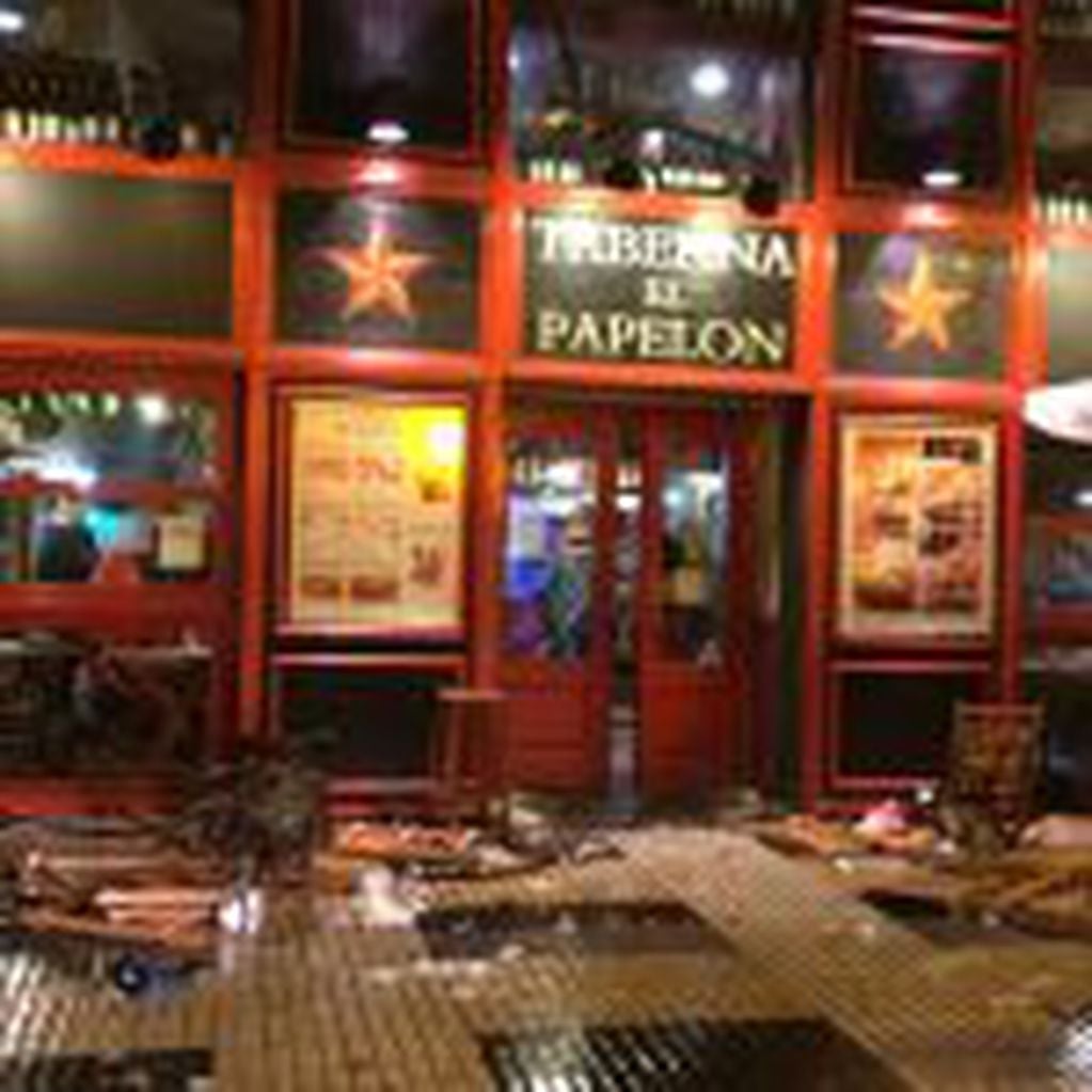 In this photo taken Monday Nov. 21, 2016, in Seville, Spain, debris lies strewn outside a bar after clashes between soccer fans. Spanish authorities say an unidentified man was stabbed late Monday during an altercation between fans ahead of Tuesday's Champions League match between Sevilla and Juventus. (AP Photo/Alvaro Ramirez, ElDesmarque.com)