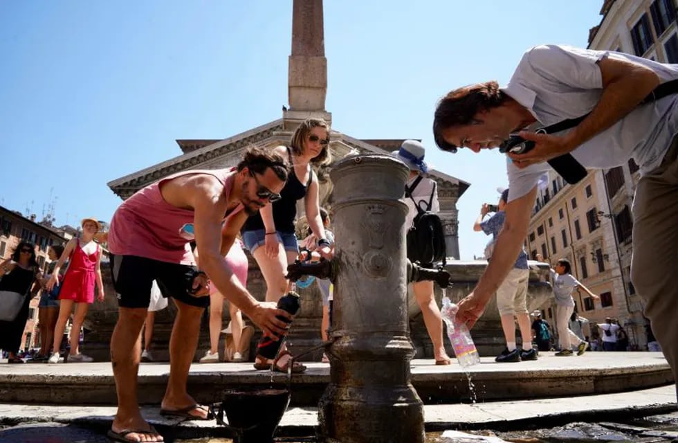 Imagen archivo. Personas recolectan agua de una fuente pública en una tarde de calor en el Panteón de Roma. Foto: AP Photo/Andrew Medichini.
