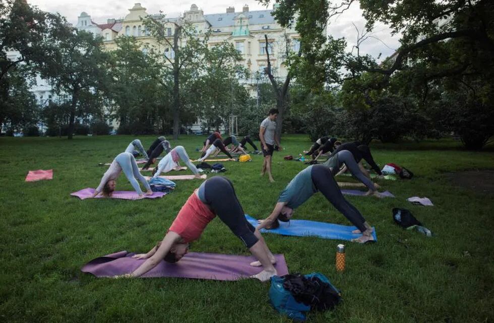 People practice yoga on June 22, 2020 at Riegrovy sady park in Prague, Czech Republic. (Photo by Michal Cizek / AFP)