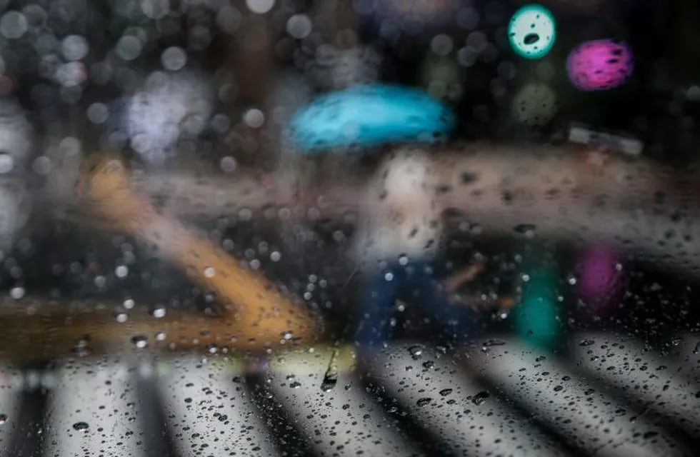 EPA2230. MAKATI (FILIPINAS), 29/10/2018.- Una mujer se protege con un paraguas mientras cruza un paso de peatones en Makati al sur de Manila (Filipinas) hoy, 30 de octubre de 2018. El tifón Yutu tocó tierra hoy en la provincia de Isabela, en el extremo nororiental de Filipinas, con intensas lluvias y vientos sostenidos de 140 kilómetros por hora, con rachas de hasta 230 kilómetros, informó la agencia local de meteorología Pagasa. EFE/ Mark R. Cristino