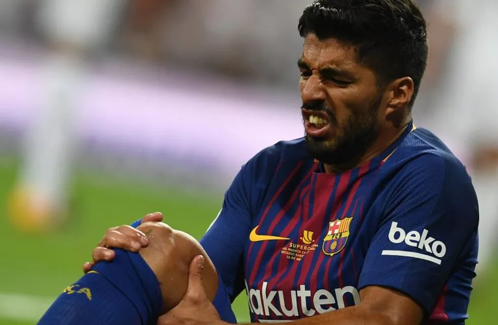 Barcelona's Uruguayan forward Luis Suarez grimaces as he sits on the ground during the second leg of the Spanish Supercup football match Real Madrid vs FC Barcelona at the Santiago Bernabeu stadium in Madrid, on August 16, 2017. / AFP PHOTO / GABRIEL BOUYS