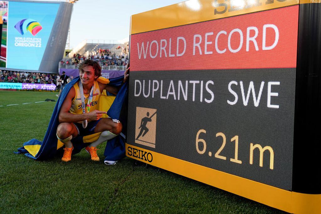 Armand Duplantis, enfundado en los colores de su país, muestra orgulloso el récord mundial de salto con garrocha que estableció en Eugene. (AP)