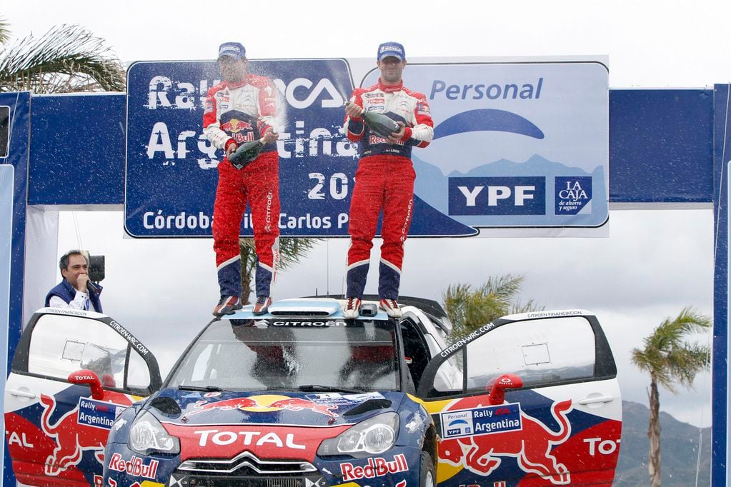 Loeb y su navegante Elena, presentados en el podio por el autor de esta nota, cuando la dupla francesa ganó el Rally de Argentina 2011.