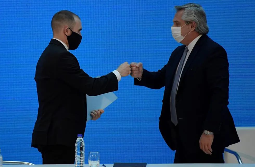 El presidente Alberto Fernández choca su puño con el ministro de Economía Martín Guzmán. (Juan Mabromata/Pool via AP)
