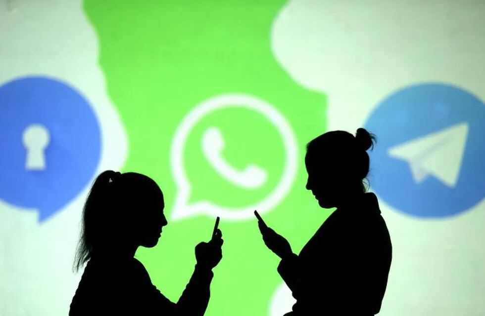 REFILE - CLARIFYING CAPTION Silhouettes of mobile users are seen next to logos of social media apps Signal, Whatsapp and Telegram projected on a screen in this picture illustration taken March 28, 2018.  REUTERS/Dado Ruvic/Illustration   internet redes sociales logos empresas ilustracion gente usando redes sociales a traves de celulares y notebooks