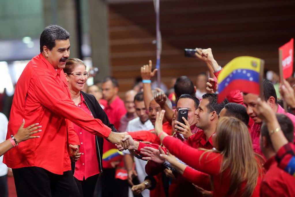 This handout picture released by the Venezuelan presidency shows President Nicolas Maduro (L) and First Lady Cilia Flores (2nd-L) greeting supporters during a rally at the Poliedro stadium in Caracas on February 2, 2018.
Venezuela's ruling Socialist Party on Friday confirmed that President Nicolas Maduro is its official candidate in a snap election due before the end of April. / AFP PHOTO / Venezuelan Presidency / HO / RESTRICTED TO EDITORIAL USE-MANDATORY CREDIT "AFP PHOTO/VENEZUELAN PRESIDENCY/HO" NO MARKETING NO ADVERTISING CAMPAIGNS-DISTRIBUTED AS A SERVICE TO CLIENTS-GETTY OUT venezuela nicolas maduro chavismo busca adelantar los comicios presidente proclamado candidato del partido para las proximas elecciones crisis economica y politica en el pais