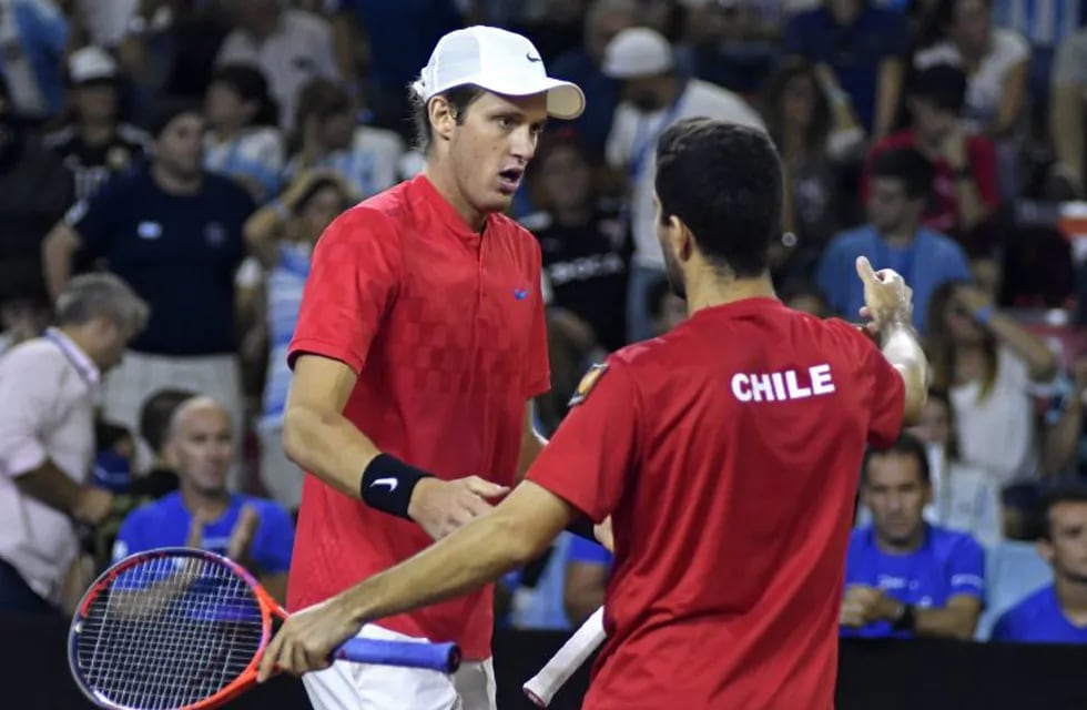 Chile's tennis players Nicolas Jarry (L) and Hans Podlipnik celebrate after defeating Argentina's tennis players Guido Pella and Maximo Gonzalez during their 2018 Davis Cup Americas Group second round doubles tennis match at Aldo Cantoni stadium in San Juan, Argentina on April 7, 2018. / AFP PHOTO / Andres Larrovere