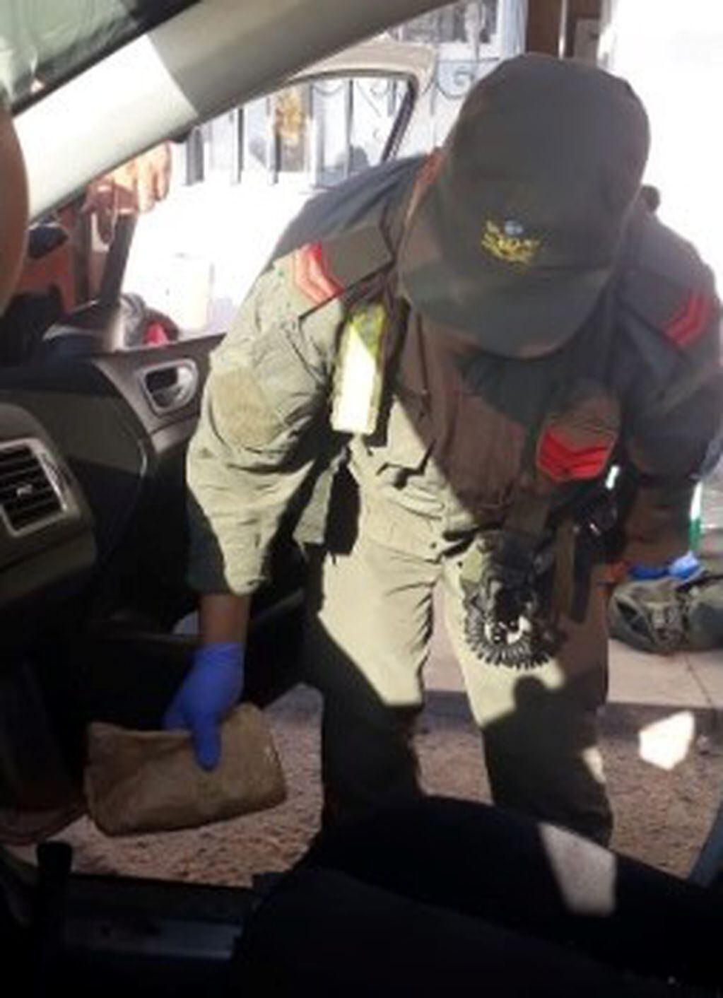 Un efectivo de la Gendarmería exhibe uno de los paquetes hallados en el vehículo.
