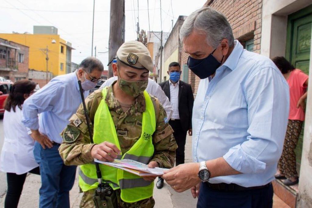 El gobernador Morales revisa con un integrante del operativo, el avance del recorrido por el barrios Lujan de San Salvador de Jujuy.