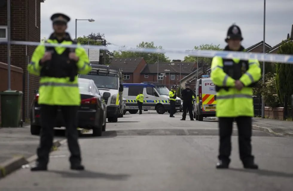 Police officers guard the entrance to a street in the Moss Side area of Manchester on May 28, 2017 during an operation.nA British minister said Sunday members of suicide bomber Salman Abedi's network could still be a large, as thousands defied the terror threat to take part in an annual half marathon. As runners pounded the streets of the northwestern English city, police arrested a 25-year-old man in the eastern Old Trafford area, bringing the number now detained on UK soil in connection with the attack to 12.n / AFP PHOTO / JOHN SUPER