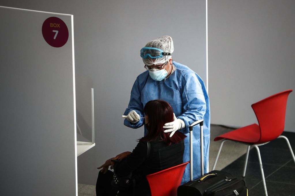 personal sanitario realiza una prueba de coronavirus a una viajera en una terminal de transporte. (Foto: EFE/ Juan Ignacio Roncoroni)