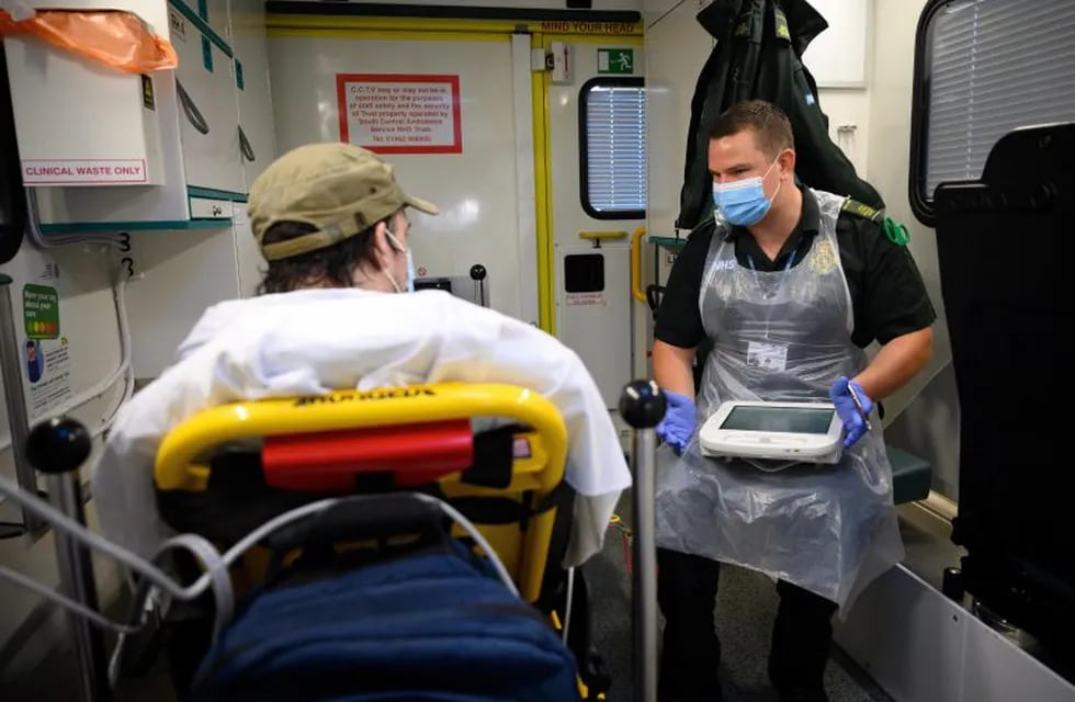 Portsmouth (United Kingdom).- Paramedic James Hansford (R) treats a patient who has previously tested positive for the COVID-19 virus for a separate issue, after responding to a 999 call, in Portsmouth, Britain, 06 May 2020 (issued 07 May 2020). As the list of recognised Covid-19 symptoms grows, paramedic crews like those with the South Central Ambulance Service are forced to treat every patient as being a potential case, often requiring specialised personal protective equipment (PPE). Paramedics now routinely don what the NHS refers to as Level 2 PPE, like face masks and disposable aprons. Cases with patients potentially needing airway procedures require Level 3 PPE, such as full-face visors and long-sleeved surgical gowns. While the infection rate is falling, and government officials are discussing ways to relax the country's quarantine measures, Covid-19 still creates everyday risks for paramedics and other first responders. (Lanzamiento de disco, Reino Unido) EFE/EPA/Leon Neal / PO