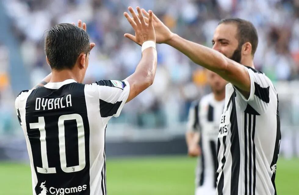 Juventus' Paulo Dybala, left, celebrates with his teammate Gonzalo Higuain after scoring, during a Serie A soccer match between Juventus and Cagliari, in Turin, Italy, Saturday, Aug. 19, 2017. (Alessandro Di Marco/ANSA via AP)