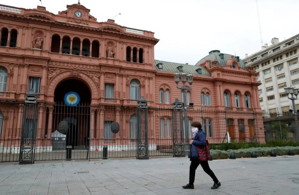 A woman wearing a face mask as a preventive measure against the coronavirus disease (COVID-19), walks in front the Casa Rosada Presidential Palace, in Buenos Aires, Argentina May 21, 2020. REUTERS/Agustin Marcarian