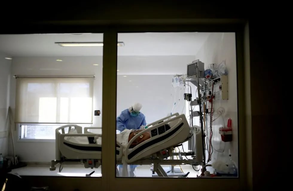 Dr. Adriana Coronel attends to a COVID-19 patient at the Eurnekian Ezeiza Hospital on the outskirts of Buenos Aires, Argentina, Tuesday, July 14, 2020, during a government-ordered lockdown to curb the spread of the new coronavirus. (AP Photo/Natacha Pisarenko)
