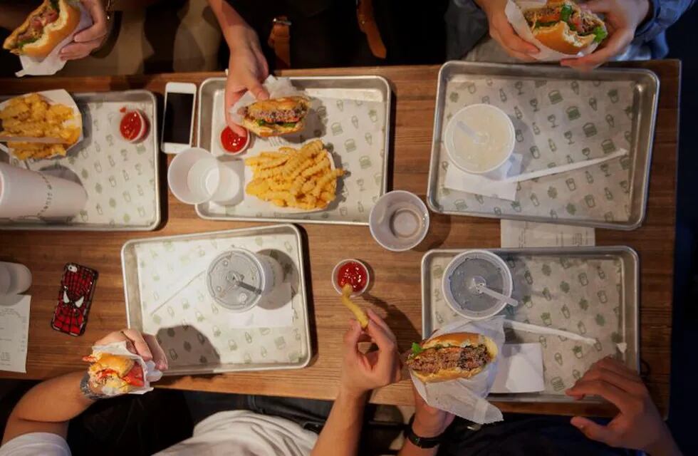 Customers dine at a Shake Shack restaurant in New York, U.S., on Wednesday, Sept. 10, 2014. Shake Shack, the burger chain started by restauranteur Danny Meyer as a kiosk in a New York City park, is preparing for an initial public offering that could value it as high as $1 billion, people familiar with the matter said. Photographer: Michael Nagle/Bloomberg eeuu nueva york  eeuu restaurante Shake Shack cadenas de comida rapida fast food