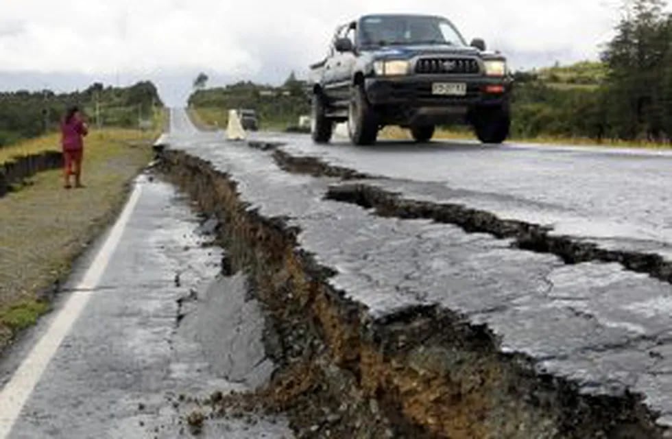CHI005. CHILOE (CHILE), 25/12/2016.- Personas transitan por una carretera destruida hoy, domingo 25 de diciembre de 2016, en Tarahuin, en la isla de Chilou00e9, localidad distante a 1.250 km. al sur de Santiago (Chile). El terremoto de magnitud 7,6 registrado