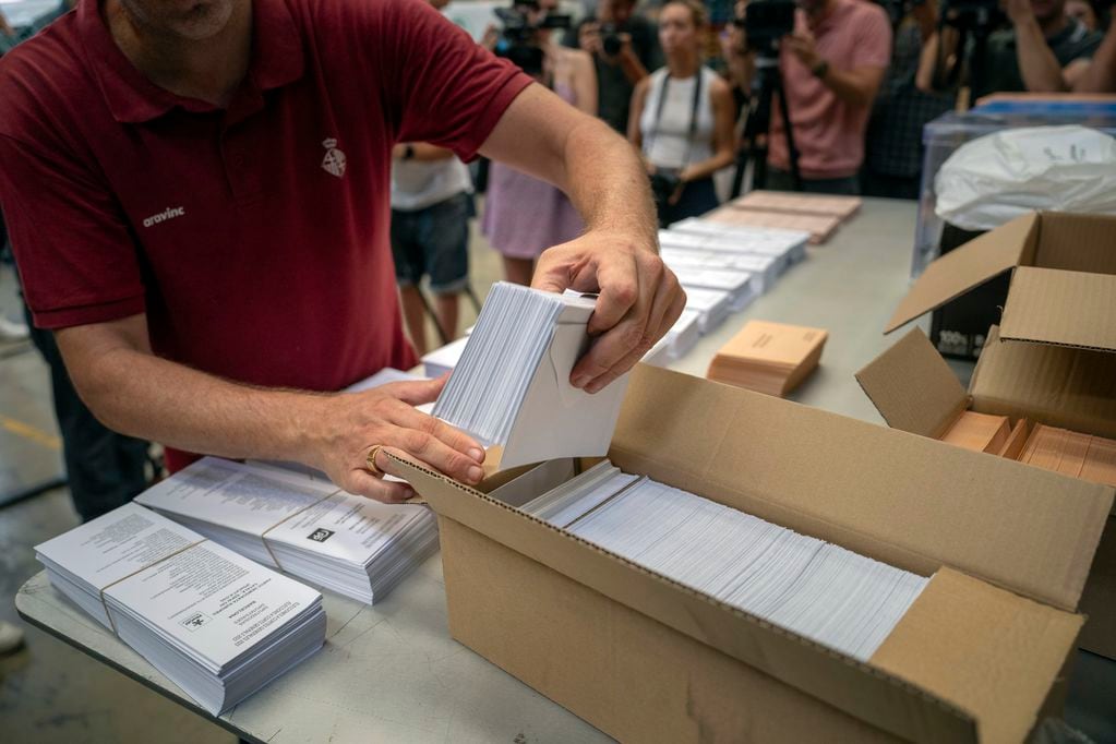 Un trabajador electoral muestra boletas a los medios antes de distribuirlos a centros de votación en un almacén de Barcelona, España, el 18 de julio de 2023. (AP Foto/Emilio Morenatti, Archivo)