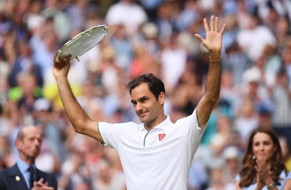 Switzerland's Roger Federer holds up the runners up trophy during the presentation after he was defeated by Serbia's Novak Djokovic during the men's singles final match of the Wimbledon Tennis Championships in London, Sunday, July 14, 2019. (Laurence Griffiths/Pool Photo via AP)