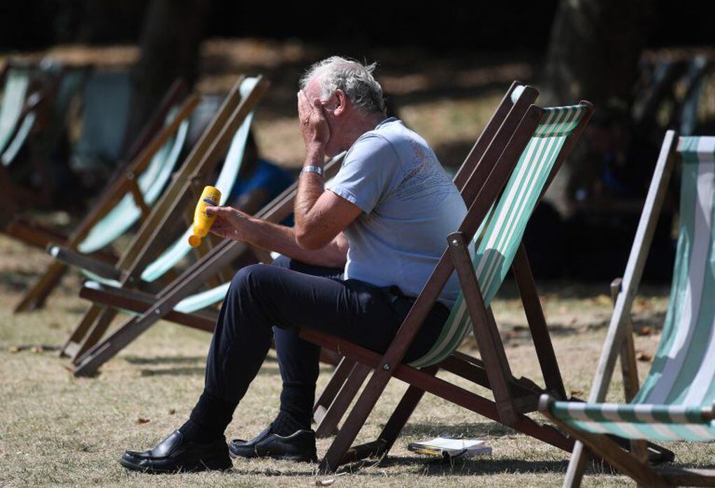 Calor infernal en Inglaterra: Un hombre se pone crema solar en el Green Park de Londres, Reino Unido.