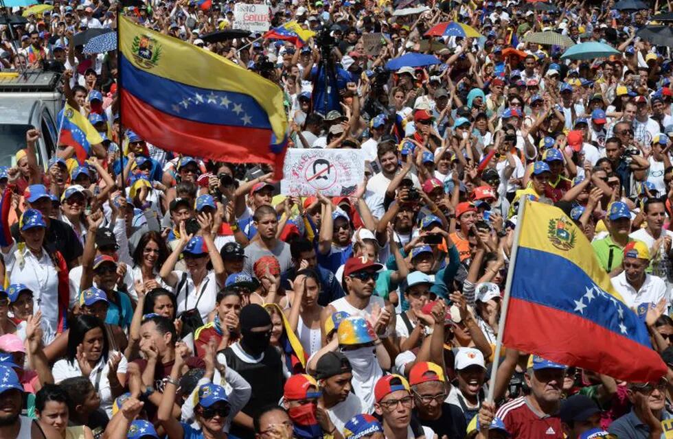 Thousands of opposition activists take part in a demonstration marking 100 days of protests against Venezuelan President Nicolas Maduro in Caracas, on July 9, 2017.\nVenezuela hit its 100th day of anti-government protests on Sunday, one day after its most prominent political prisoner, Leopoldo Lopez, vowed to continue his fight for freedom after being released from jail and placed under house arrest. At least 91 people have died since non-stop street protests began on April 1. / AFP PHOTO / Federico PARRA