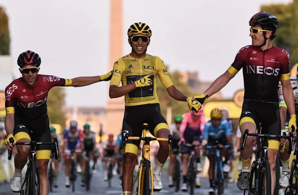 TOPSHOT - Spain's Jonathan Castroviejo (L) and Great Britain's Geraint Thomas (R) congratulate Colombia's Egan Bernal (C), wearing the overall leader's yellow jersey, as he celebrates his victory on the finish line of the 21st and last stage of the 106th edition of the Tour de France cycling race between Rambouillet and Paris Champs-Elysees, in Paris, in Paris on July 28, 2019. (Photo by Anne-Christine POUJOULAT / AFP)