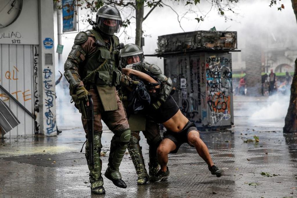 La policía antidisturbios detiene a un manifestante cuando estallaron los enfrentamientos tras una protesta contra el gobierno del presidente Sebastián Piñera en Santiago, el 8 de noviembre de 2019. Crédito: JAVIER TORRES / AFP.