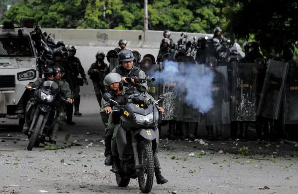 -FOTODELDIA- CAR19. CARACAS (VENEZUELA), 28/07/2017.- Efectivos de la Guardia Nacional Bolivariana (GNB) enfrentan a un grupo de manifestantes durante una protesta antigubernamental hoy, viernes 28 de julio de 2017, en Caracas (Venezuela). Los opositores comenzaron con la primera de tres jornadas de protestas convocadas para los próximos tres días atrancando calles con barricadas, obstáculos y montones de basura como forma de protesta contra la Asamblea Nacional Constituyente, que se elegirá el próximo domingo. EFE/Miguel Gutiérrez