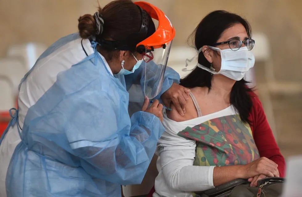 Una trabajadora de la salud aplicando una vacuna en el vacunatorio del Comedor Universitario de Córdoba. (Pedro Castillo/ La Voz)