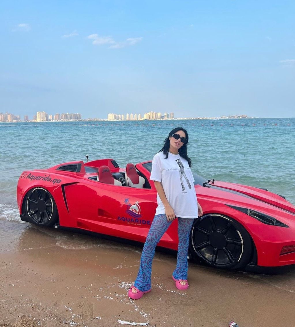 Lali lució sandalias rosas con plataforma en la playa de los Emiratos Árabes.