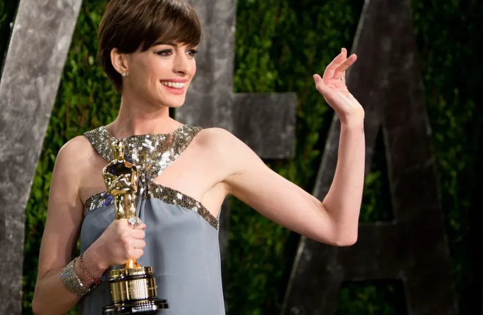 Anne Hathaway carrying her Oscar for best supporting actress arrives for the 2013 Vanity Fair Oscar Party on February 24, 2013 in Hollywood, California.   AFP PHOTO / ADRIAN SANCHEZ-GONZALEZ los angeles eeuu Anne Hathaway entrega premios Oscar 2013 actriz  llegada fiesta Vanity Fair ganadora premio mejor actriz de reparto