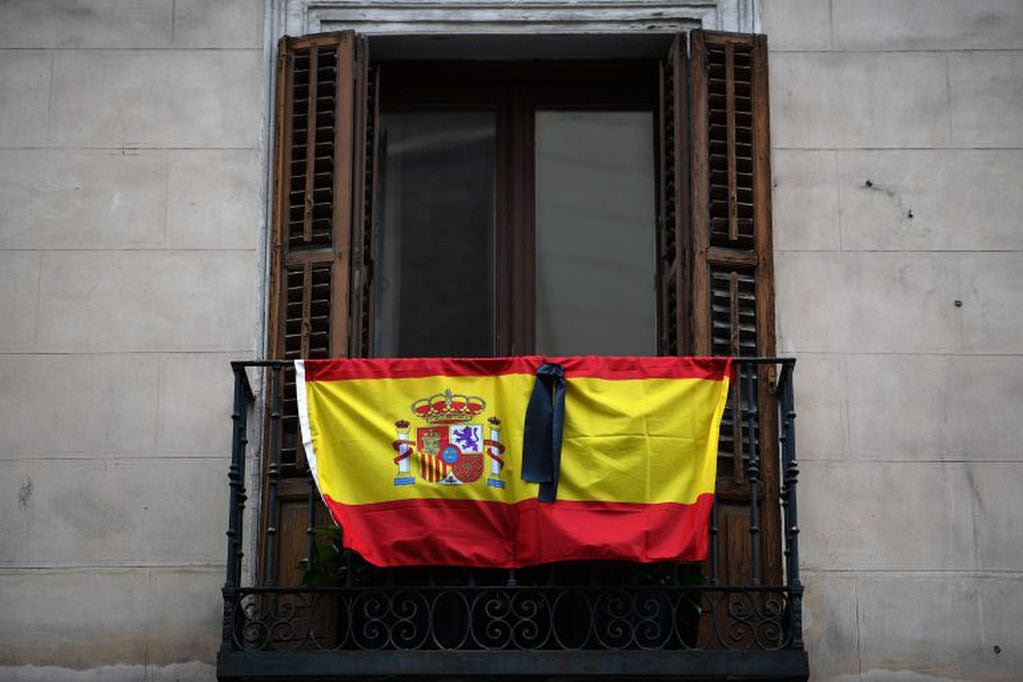 La bandera española con una cinta negra de luto por las muertes por coronavirus (Foto: Gabriel BOUYS / AFP)