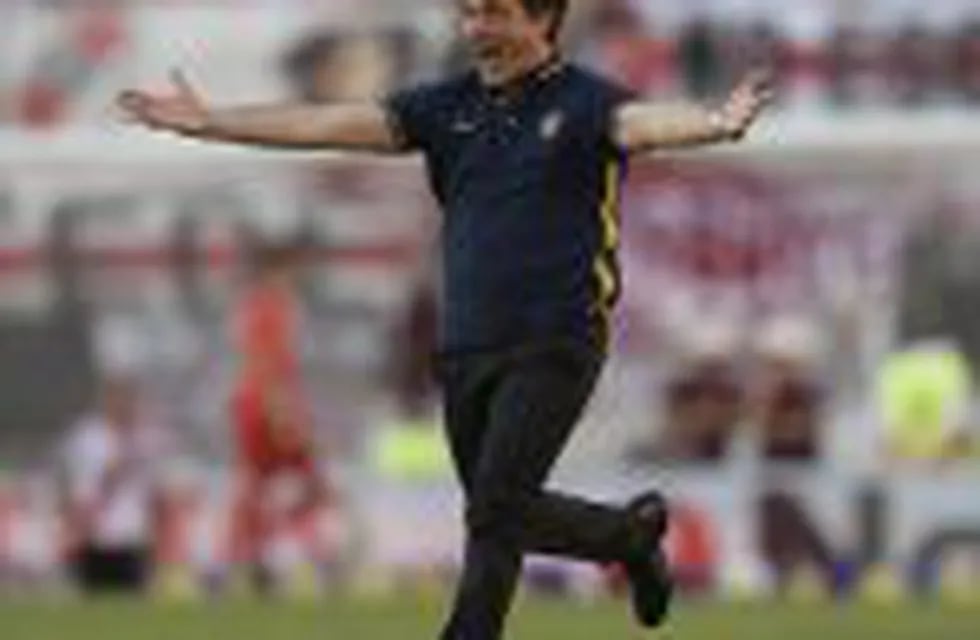Boca Juniors' coach Guillermo Barros Schelotto celebrates after forward Ricardo Centurion (not in frame) scored the team's fourth goal against River Plate during their Argentine first division football match at the Monumental stadium in Buenos Aires, Arge