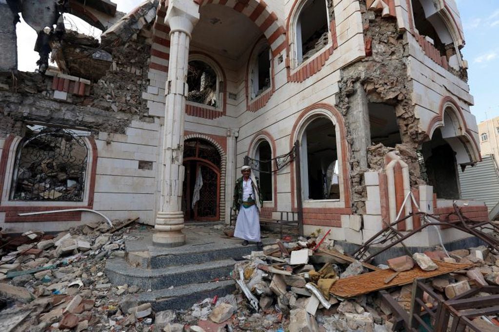 Un yemení posa junto a los escombros de un edificio destruido tras un supuesto ataque de la coalición liderada por Arabia Saudí, en Saná. Crédito: EFE/ Yahya Arhab.