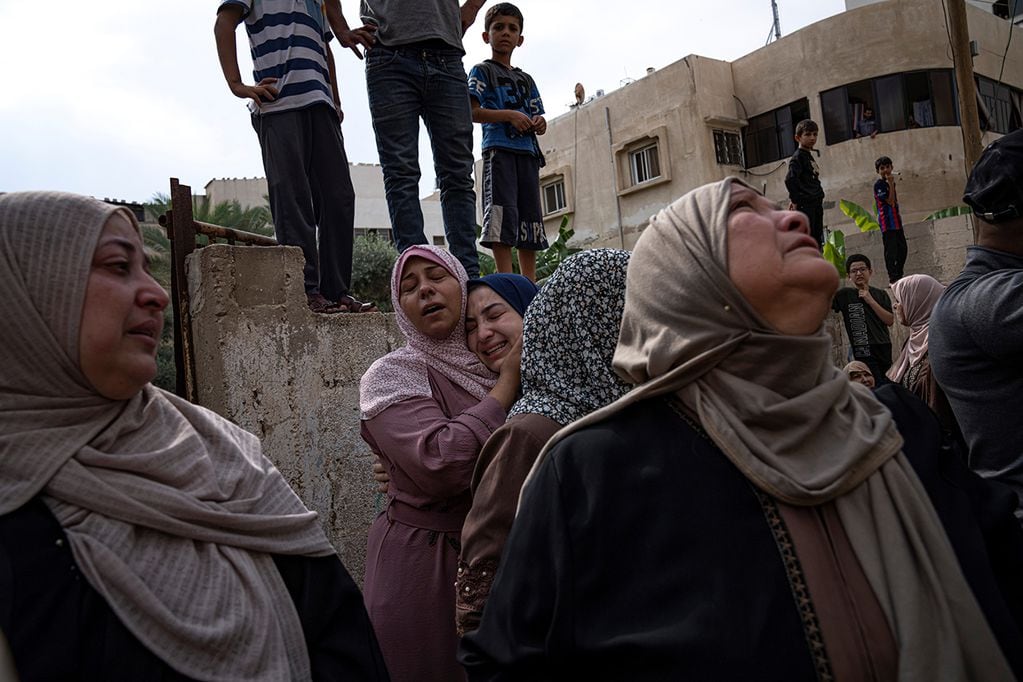 Familiares lloran a las personas muertas en un ataque aéreo israelí en la ciudad de Gaza. (AP)