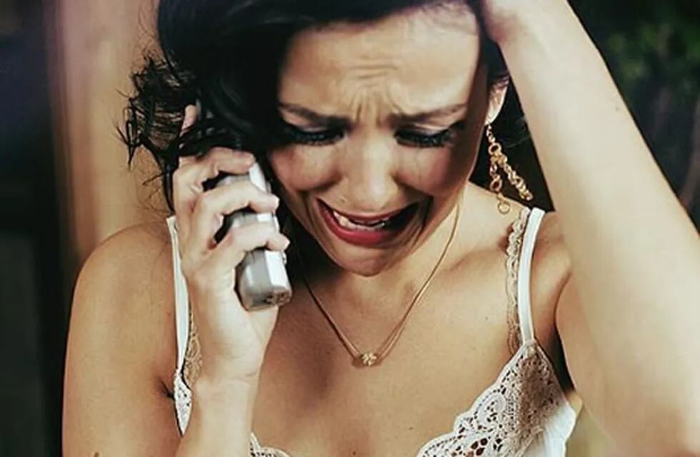 Mujer llora al teléfono